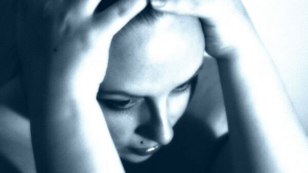 Kvinna som håller händerna på huvudet