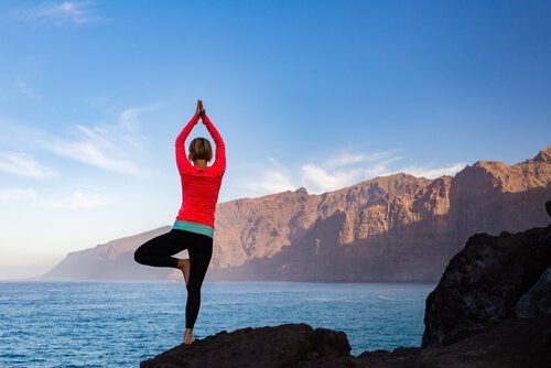 Kvinna som gör yogaställningen Vrksasana