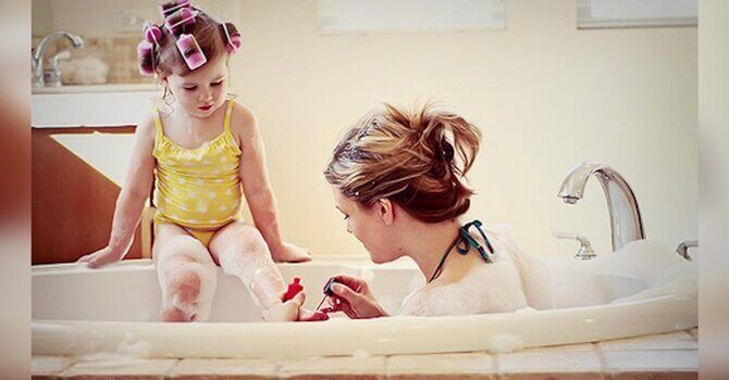 Mamma i badet med sitt barn.
