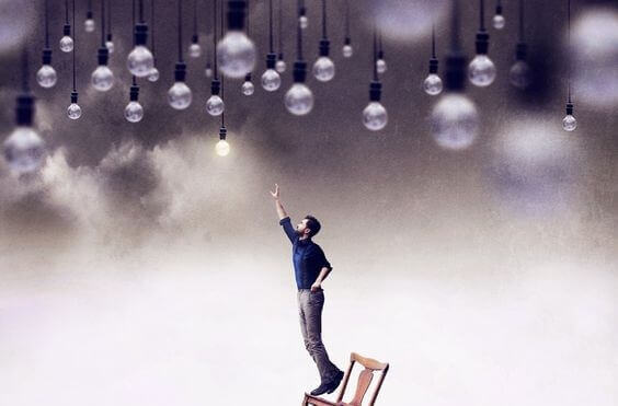 Praktisk person på stol som sträcker sig efter glödlampor