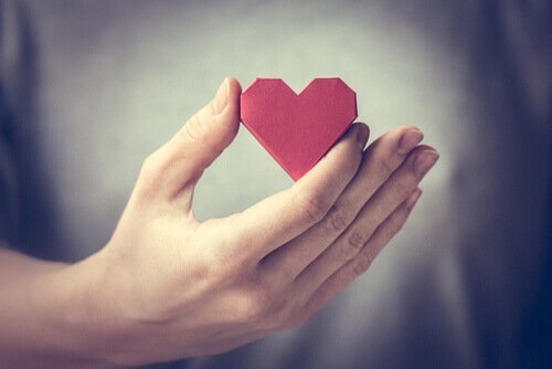 Person som håller ett hjärta i handen.
