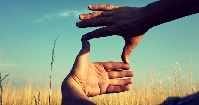 Händer som ramar in ett fält.