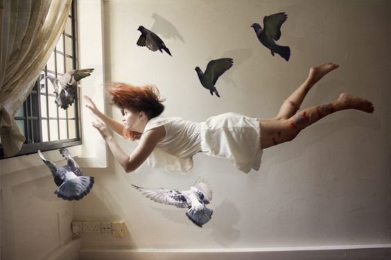 Kvinna som flyger bland duvor.
