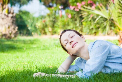 Kvinna som ligger i gräset och har lärt sig att hantera kaos