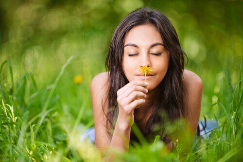 Kvinna som luktar på blomma.