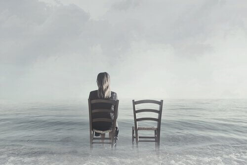 Kvinna som sitter på en stol i havet.