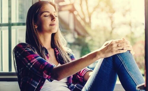 Kvinna som sitter vid fönstret och har lärt sig hantera kaos