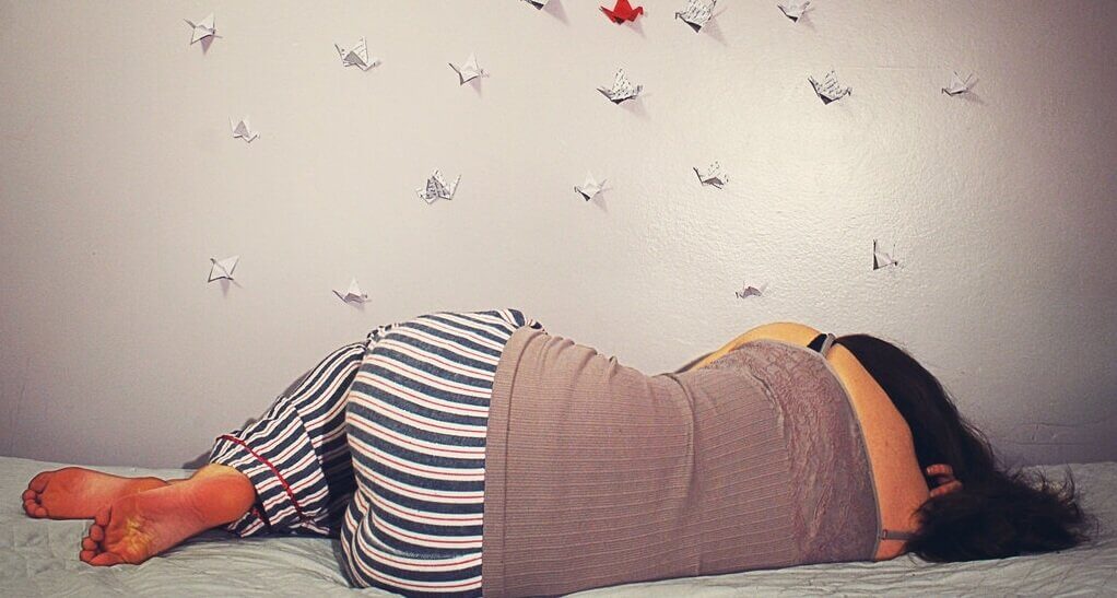 Kvinna som sover på sängen och illustrerar intressanta saker om drömmar