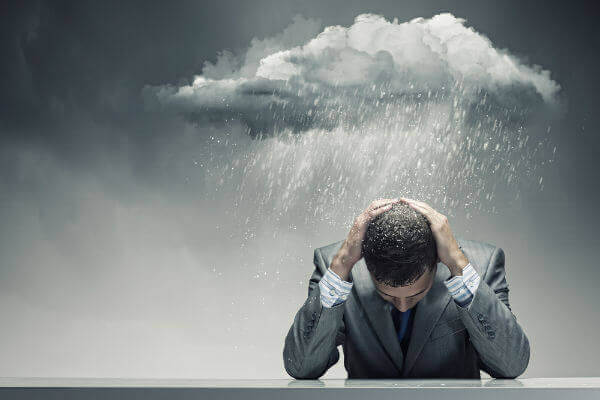 Man med moln över huvudet.