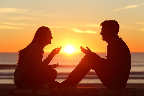 Man och kvinna som samtalar på stranden.