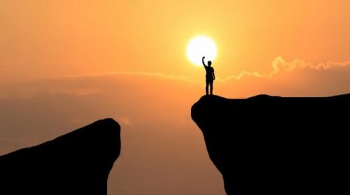 Man på en klippa vid solnedgången