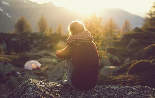 Kvinna som sitter vid ett berg.