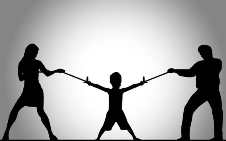 Barn som står mellan två vuxna.