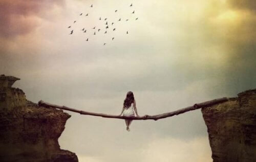 Kvinna som sitter på en stam mellan klippor