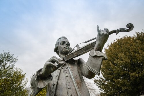 En staty av Mozart som spelar fiol.