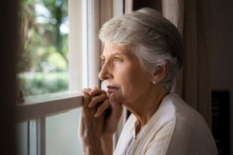 Äldre kvinna vid fönster