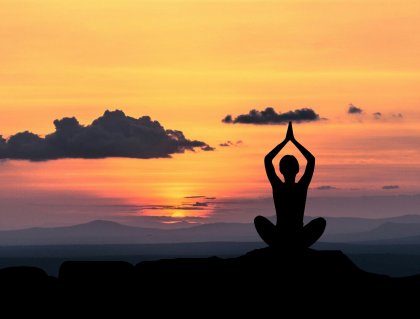 Person som mediterar i solnedgången mot förväntansångest