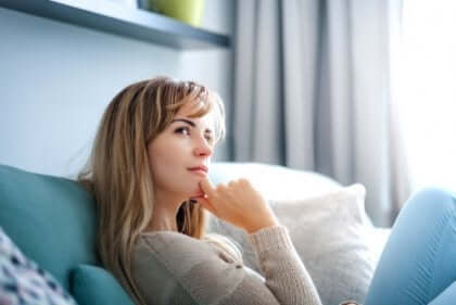 Kvinna som sitter i soffan och tänker.