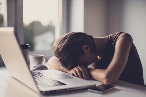 Kvinna som sover vid laptop.