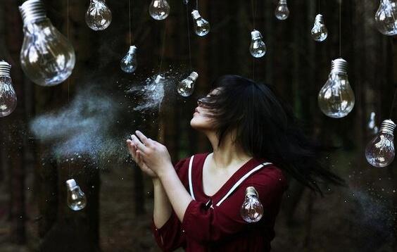 Kvinna som står bland glödlampor.