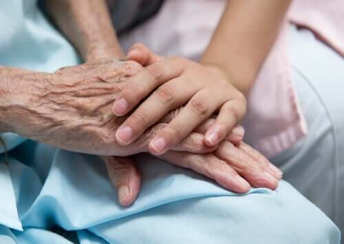 Vårdgivare som vilar handen på sin patients händer