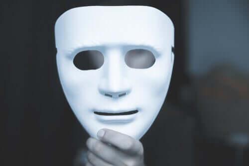 Person som håller upp vit mask.