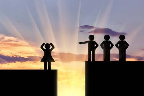 Tre manliga figurer som står på en plattform ovanför en kvinna och pekar ned på henne.