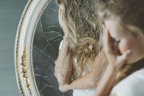 Kvinna framför söndrig spegel.