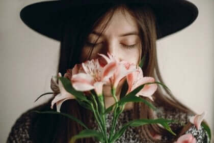 Kvinna som luktar på blommor.