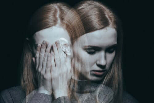 En kluven kvinna med händerna för ansiktet och en spegelbild av henne som ser ledsen ut.