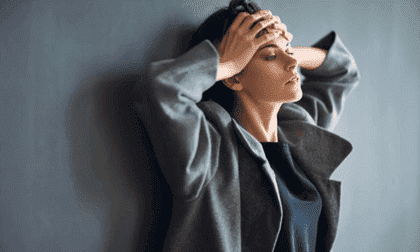 Kvinna med ryggen mot väggen.