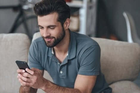 En man som läser något trevligt på sin telefon