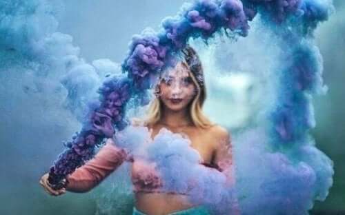 En kvinna i ett moln av lila och blå rök