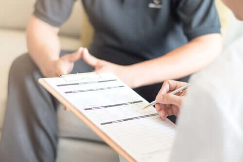 En terapeut som fyller i en patients kliniska historia innan han utför nidoterapi.