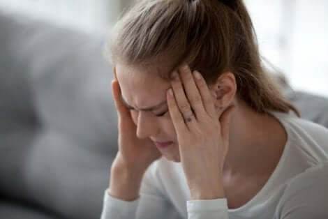 En kvinna som behöver hantera fysisk smärta från huvudvärk