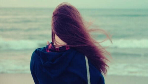 Flicka som ser ut över havet tänker på att be om hjälp