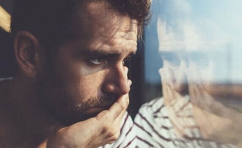 Ledsen man ser ut genom fönster