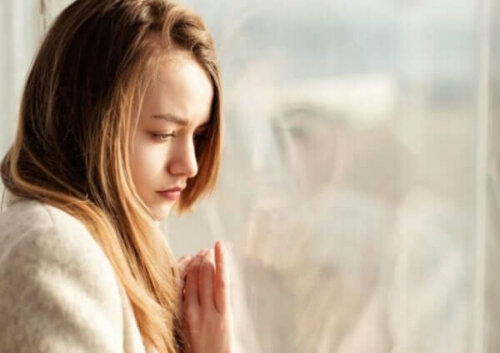 Ledsen tjej vid fönster funderar på tinderella syndrome