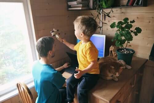 En pappa väljer att arbeta hemifrån med sin son bredvid