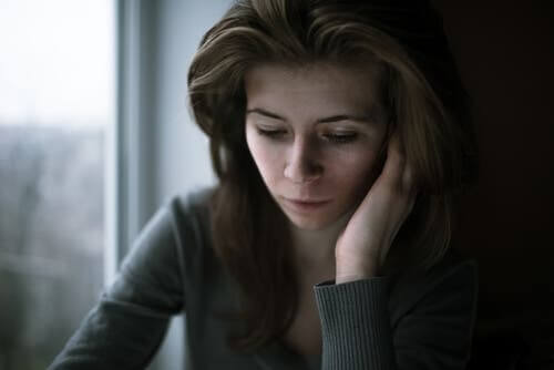 En ledsen kvinna ser ner
