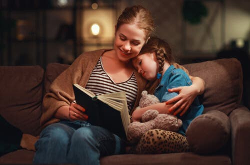 En mamma i soffan läser med sin dotter