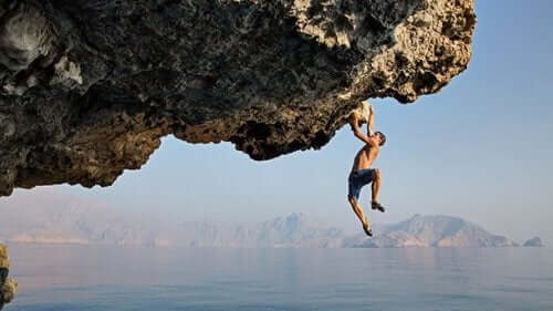 Alex Honnold klättrar under horisontell klippa över vatten