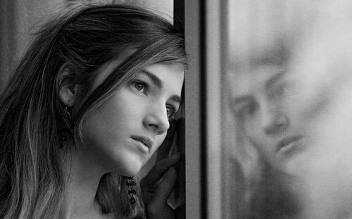 An autistisk människa ser ut genom ett fönster