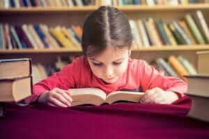 En liten flicka i fart med att lära sig läsa