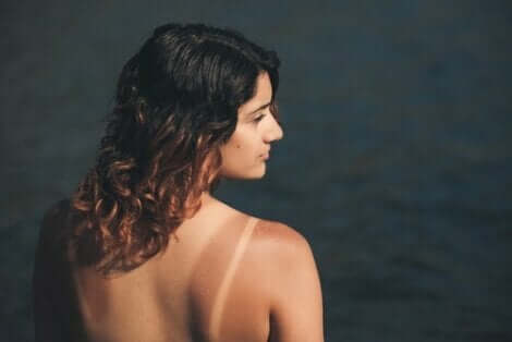 En solbränd kvinna som står framme vid vattnet