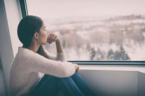 Deprimerad kvinna vid fönster