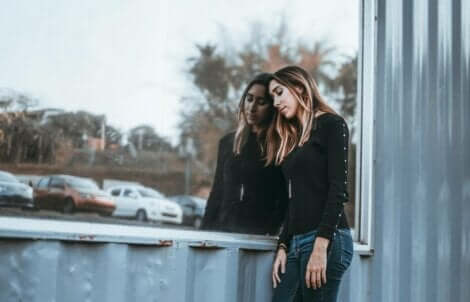 En kvinna som lutar sig mot en glasruta