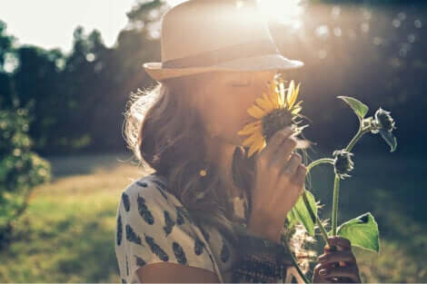 En kvinna som luktar på en solros