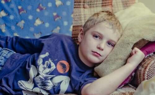 En ledsen pojke som ligger på soffan