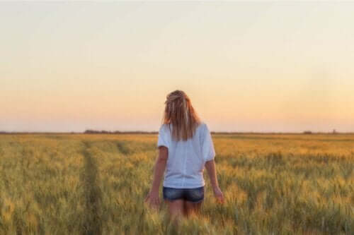 En kvinna vandrar på ett vetefält